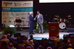 U.S. Congressman Harold “Hal” Rogers and UK Men’s Basketball Coach John Calipari shake hands on stage at the SOAR Summit.